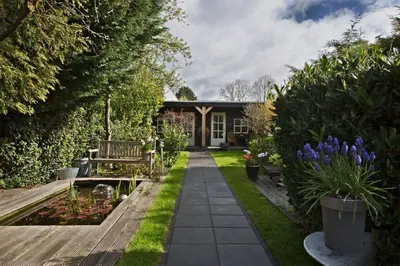 a garden with a bench and some plants and flowers at B&B Hoofddorp in Hoofddorp