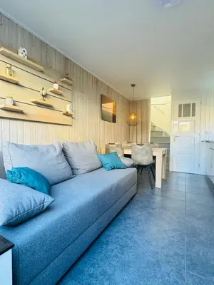 a living room with a blue couch and a table at Beachhouse R&M in Noordwijk aan Zee