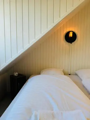 a bed in a room with a wall at Beachhouse R&M in Noordwijk aan Zee