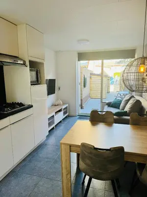 a kitchen with a dining table and a living room at Beachhouse R&M in Noordwijk aan Zee