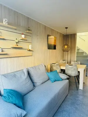 a living room with a blue couch and a table at Beachhouse R&M in Noordwijk aan Zee