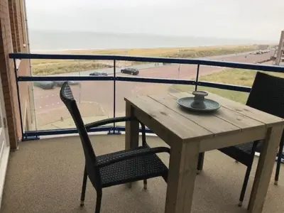 a table and chairs on a balcony with a view at Atlantis 16b in Egmond aan Zee