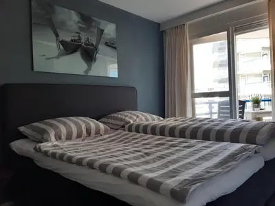 a bedroom with two beds and a window at Atlantis 16b in Egmond aan Zee