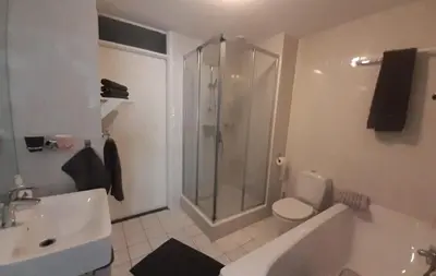 a bathroom with a shower and a toilet and a sink at Atlantis 16b in Egmond aan Zee