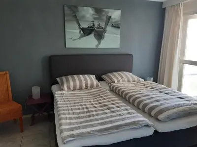 two beds in a bedroom with a picture on the wall at Atlantis 16b in Egmond aan Zee