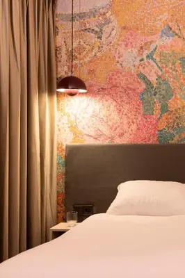 a bedroom with a bed and a wall with a map at THE FRITZ Hotel Amsterdam in Amsterdam