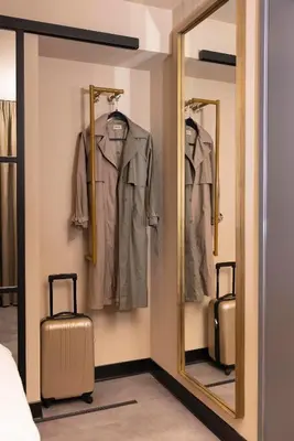 a dressing room with a mirror and suitcases at THE FRITZ Hotel Amsterdam in Amsterdam