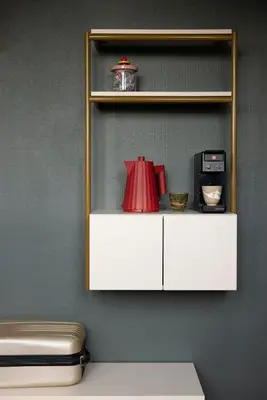 a white cabinet with a red item on a wall at THE FRITZ Hotel Amsterdam in Amsterdam