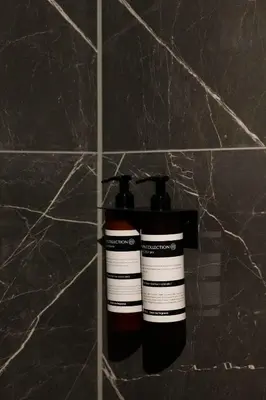 a couple of bottles on a wall in a bathroom at THE FRITZ Hotel Amsterdam in Amsterdam