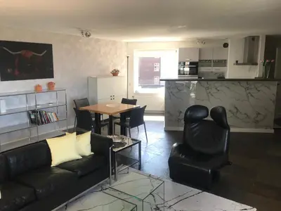 a living room with a couch and a table and chairs at Meerblick Atlantis 17 c in Egmond aan Zee