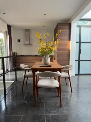a dining room table with chairs and a vase with flowers at Luxury semi-detached house near Amsterdam in Loenen aan de Vecht