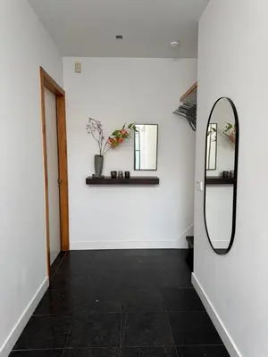 a hallway with a mirror and a white wall at Luxury semi-detached house near Amsterdam in Loenen aan de Vecht
