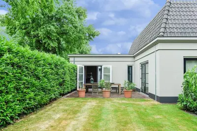 a white house with a yard with potted plants at Luxury semi-detached house near Amsterdam in Loenen aan de Vecht