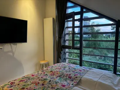 a bedroom with a bed and a large window at Villa Happy Days in Egmond aan Zee