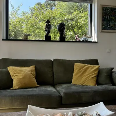 a couch sitting in a living room with a window at Villa Happy Days in Egmond aan Zee