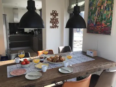 a dining room table with food and glasses of wine at Villa Happy Days in Egmond aan Zee