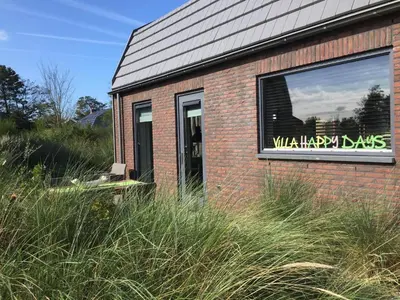 a brick building with a sign in a window at Villa Happy Days in Egmond aan Zee