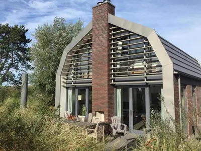 a brick house with a large glass facade at Villa Happy Days in Egmond aan Zee