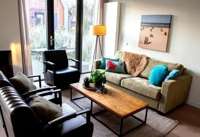 a living room with a couch and a coffee table at Villa Duinroos in Egmond aan den Hoef