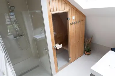 a bathroom with a shower and a toilet and a sink at Villa Duinroos in Egmond aan den Hoef