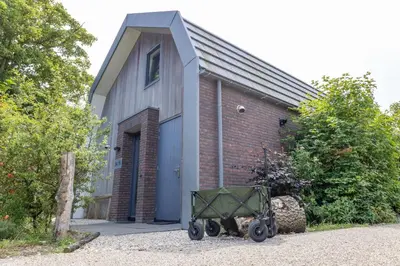 a brick building with a wagon in front of it at Villa Duinroos in Egmond aan den Hoef