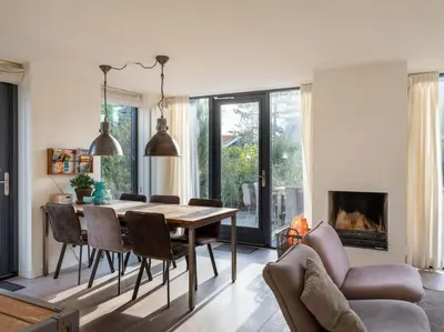 a living room with a dining room table and chairs at Villa Zeester in Egmond aan den Hoef