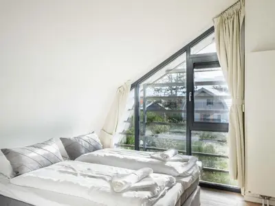 a living room with a couch and a large window at Villa Zeester in Egmond aan den Hoef