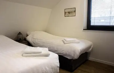 two beds in a room with towels on them at Villa Zeester in Egmond aan den Hoef