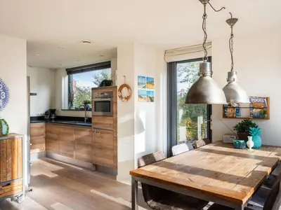 a kitchen and dining room with a wooden table in a house at Villa Zeester in Egmond aan den Hoef