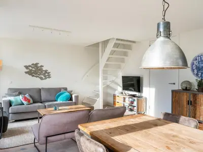 a living room with a table and a couch at Villa Zeester in Egmond aan den Hoef