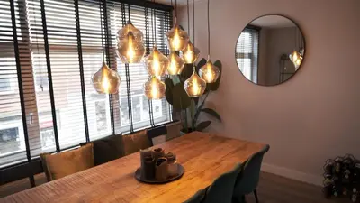 a dining room with a table and a mirror at 't Sand Apartment in Zandvoort