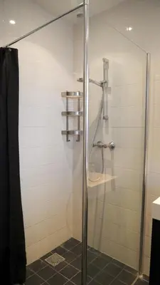 a shower with a glass door in a bathroom at 't Sand Apartment in Zandvoort