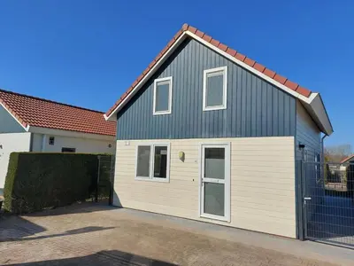 a gray and white house with a garage at Waterlelie Vakantiepark De Groote Vliet in Wervershoof