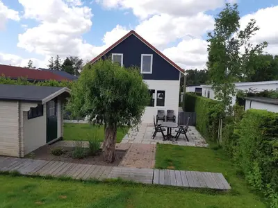 a house with a picnic table in the yard at Waterlelie Vakantiepark De Groote Vliet in Wervershoof