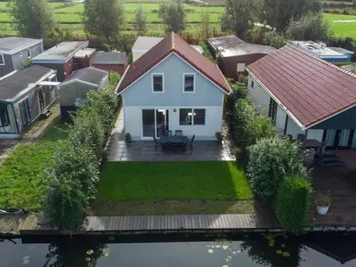 an aerial view of a white house with a yard at Waterlelie Vakantiepark De Groote Vliet in Wervershoof
