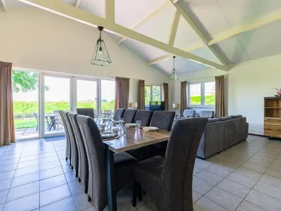 a dining room with a table and chairs at Wilgenroos Vakantiepark De Groote Vliet in Wervershoof