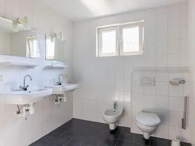 a bathroom with two sinks and a toilet at Wilgenroos Vakantiepark De Groote Vliet in Wervershoof