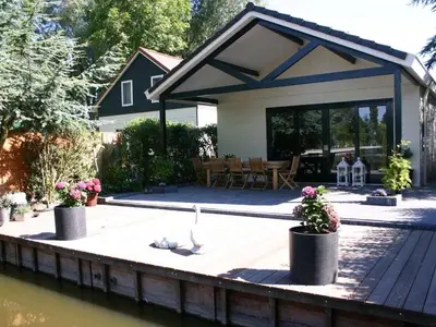 a house with a cat sitting on a dock at Bungalow in Wervershoof with 1 bedroom in Wervershoof