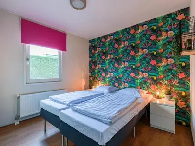 a bedroom with a large flower mural on the wall at Bungalow in Wervershoof with 1 bedroom in Wervershoof