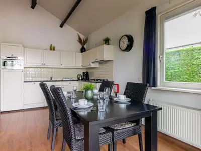 a dining room with a table and chairs and a kitchen at Bungalow in Wervershoof with 1 bedroom in Wervershoof