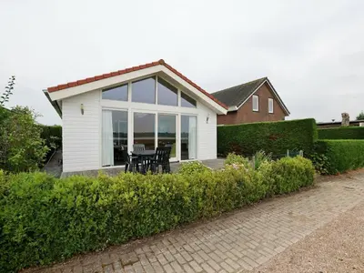 a small white house with a table and chairs at Bungalow in Wervershoof with 1 bedroom in Wervershoof