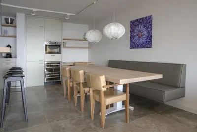 a kitchen with a wooden dining table and chairs at Atlantis 14 in Egmond aan Zee