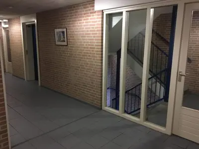 an empty hallway with a staircase in a brick wall at Atlantis 14 in Egmond aan Zee