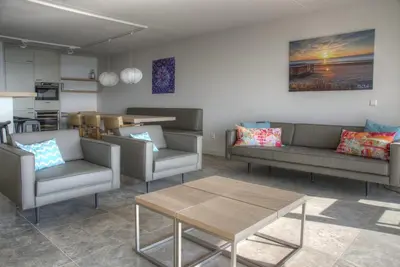 a living room with couches and a table and a kitchen at Atlantis 14 in Egmond aan Zee