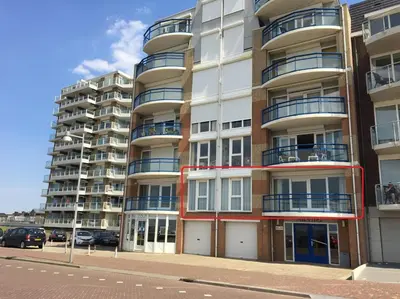a large apartment building with balconies on a street at Atlantis 14 in Egmond aan Zee