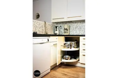 a small kitchen with white cabinets and a sink at Atlantis 18 in Egmond aan Zee