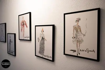 a wall with framed pictures of women on a wall at Atlantis 18 in Egmond aan Zee