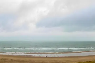 a kite flying over the ocean on a beach at Atlantis 18 in Egmond aan Zee