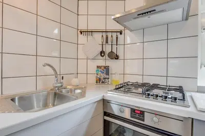 a kitchen with a sink and a stove at The White Cottage in Uitgeest
