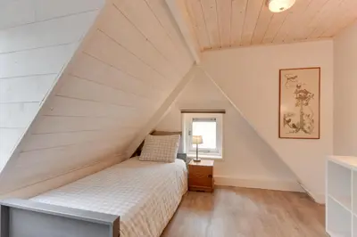 a bedroom with a bed in a attic at The White Cottage in Uitgeest